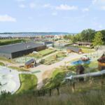 Large playground with slide, skatepark, and view of sea and holiday homes.