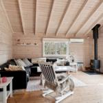 Living room with wooden walls, fireplace, and dining area with tablecloth.