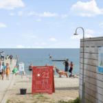 Welcome sign at beach with swimming area and shower station