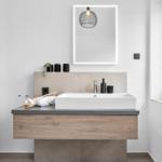 Moderne Badewanne mit Waschbecken, Spiegel und Hängelampe.