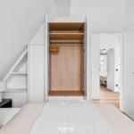 Schlafzimmer mit integriertem Kleiderschrank und Blick in den Flur.