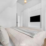 Schlafzimmer mit Bett, TV und angrenzendem Bad.