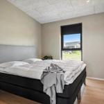 Bedroom with bed, window, and wooden floor.