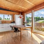 Kitchen and dining area with wooden ceiling, large windows, and view of the surroundings.