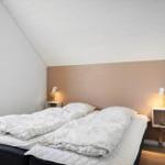 Schlafzimmer mit Doppelbett, Fenster und zwei Nachttischen mit Lampen.