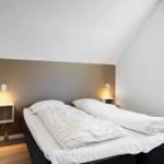Schlafzimmer mit Doppelbett, Nachttischen und Fenster.