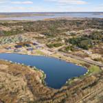 Aerial view of a residential area near a lake and larger water body.