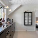 Küche mit Arbeitsplatte, Dunstabzug und Glasvitrine an der Wand