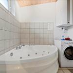 Bath with whirlpool, washing machine, and water heater on the wall.