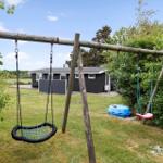 Backyard with playground equipment and small house in background.