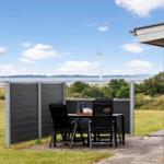 Terrace with table and chairs. View of wind turbines and water.