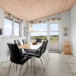 Dining room with table, chairs, and view of the landscape.