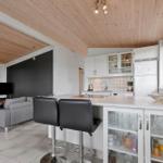 Kitchen with dining area and living room with sofa and TV.