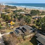 Haus mit Solaranlagen, umgeben von Wald und Strand