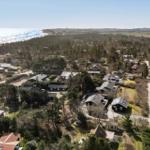 Luftbild von Ferienhäusern am Meer mit Wald und Feldern