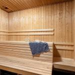 Holzsauna mit mehreren Sitzbänken und einem Handtuch.
