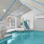 Innenpool mit Rutsche und Glasfront zum Garten.