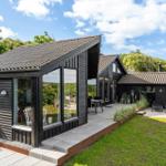 Modern wooden cabin with large terrace area and garden.