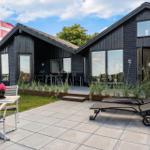 Modern villa with terrace, sun loungers, and Danish flag.