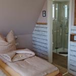 Zimmer mit Doppelbett, Dusche und Spiegel an der Wand