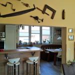 Küche mit Essbereich, Holzbar und Wanddekoration aus Werkzeugen.