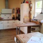 Küche mit Holzoberflächen, weißen Schränken und Fenster mit Pflanzen