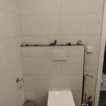 Toilette mit Wandhalter und Schale mit Muscheln und kleinen Figuren.