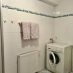 Waschmaschine in Badezimmer mit Handtuch und Heizkörper