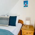 Schlafzimmer mit Bett, Nachttisch und Bild an der Wand.