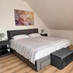 Schlafzimmer mit Doppelbett, Nachttischen und Wandbild