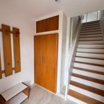 Eingang mit Holzgarderobe, Schuhschrank und Treppe nach oben.