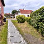 Gartenweg mit Steinen und Kies zwischen Rasen und Hecke.