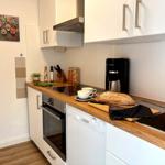 Küche mit Holzoberfläche, Spüle, Kaffeemaschine und Backofen