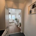 Küche mit Blick in Wohnzimmer mit Sofa und TV.