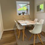 Esszimmer mit Tisch, Stühlen und Fensterblick