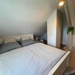 Schlafzimmer mit Dachschräge, Bett und Nachttisch
