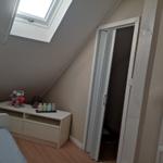 Schlafzimmer mit Dachschräge, Dachfenster und Kleiderschrank.