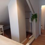 Schlafzimmer mit Kleiderschrank und Pflanze. Blick in angrenzenden Raum.
