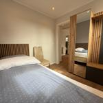 Schlafzimmer mit Bett, Spiegelschrank und Stuhl.