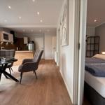 Wohnbereich mit Essbereich und Küche. Nebenraum mit Schlafzimmer und Bett.