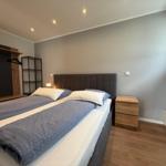 Schlafzimmer mit Doppelbett, Nachttisch und Kleiderschrank.