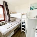 Zimmer mit Doppelstockbett, Fenster und Kleiderschrank.