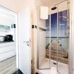 Dusche mit Meerblick-Tapete und angrenzende Küche mit Küchenschränken.