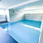 Innenpool mit blauen Fliesen und hellen Wänden