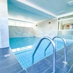 Innenpool mit Metalltreppe und blauen Fliesen