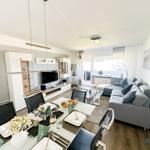 Wohn- und Essbereich mit Sofa, Esstisch und Fernseher. Terrasse mit Blick.