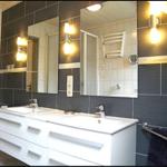Badezimmer mit Doppelwaschbecken, Spiegeln und Heizkörper