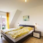 Schlafzimmer mit Doppelbett, Fenster und Nachttisch
