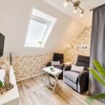 Dachgeschosszimmer mit TV, Sitzgelegenheiten und Dachfenster.