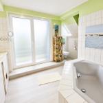 Badezimmer mit Badewanne und Zugang zum Balkon...